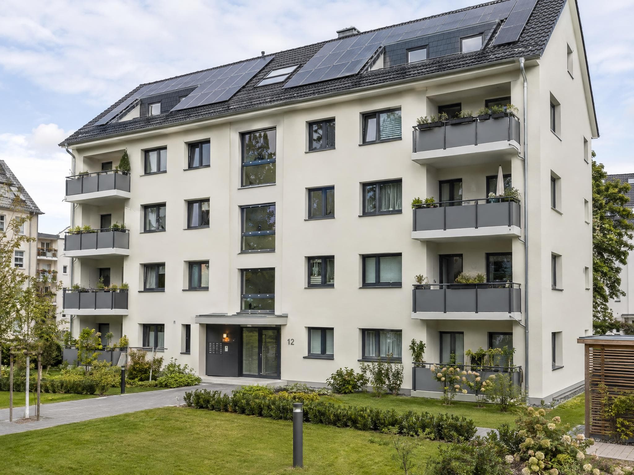 Energetische Sanierung an einem Mehrfamilienhaus mit modernisierter Fassade und neuen Fenstern